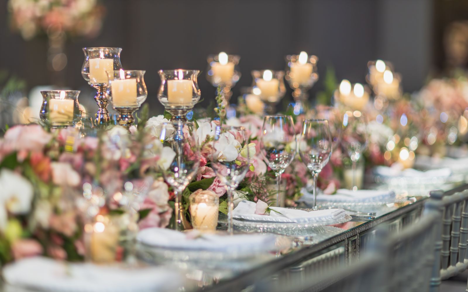 Reception tables set with rose and ivory florals under string lights